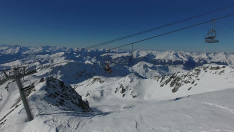 Drone-shot-flying-along-a-cable-car-with-skiers-in-la-plagne-France.